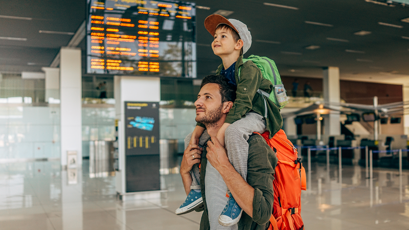 Man carrying child on his shoulders at airport