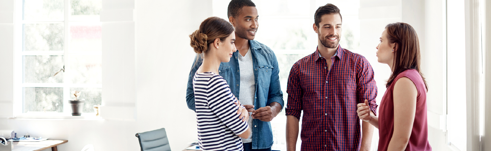 Four young professionals discussing in an office