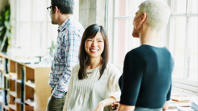 Lady smiling and laughing talking to another woman