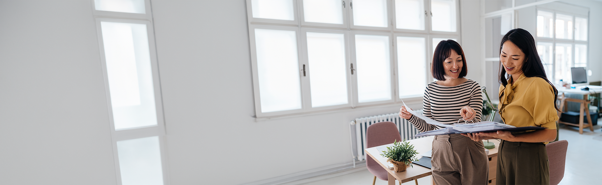 Two women looking over documents in a light and airy office
