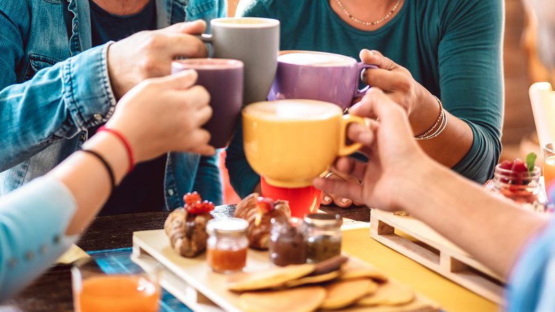 Four friends toasting with coffee cups